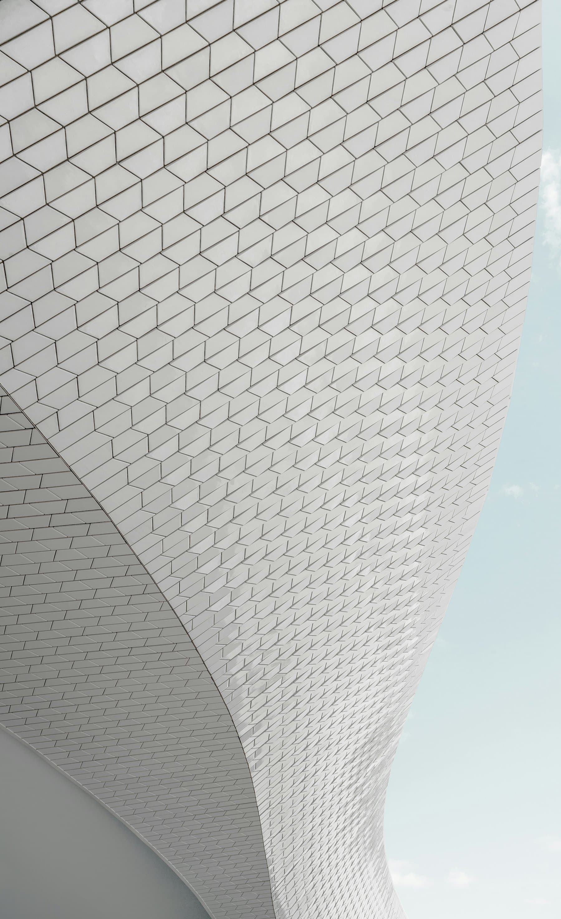 Perforated white façade panels in raking light