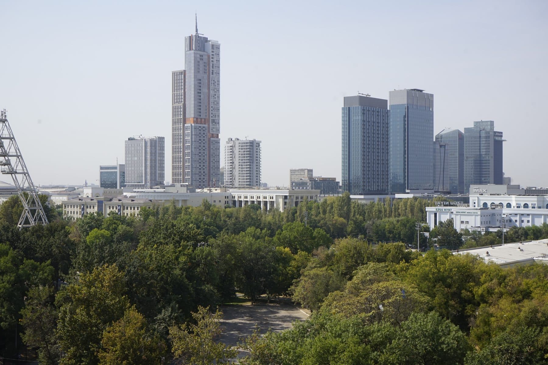 The towers of Tashkent City rising above the city's tree canopy